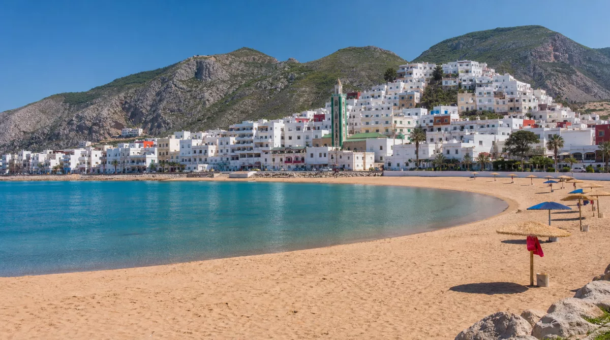 Secluded cove beach near Al Hoceima with turquoise water, white sand and dramatic rocky cliffs